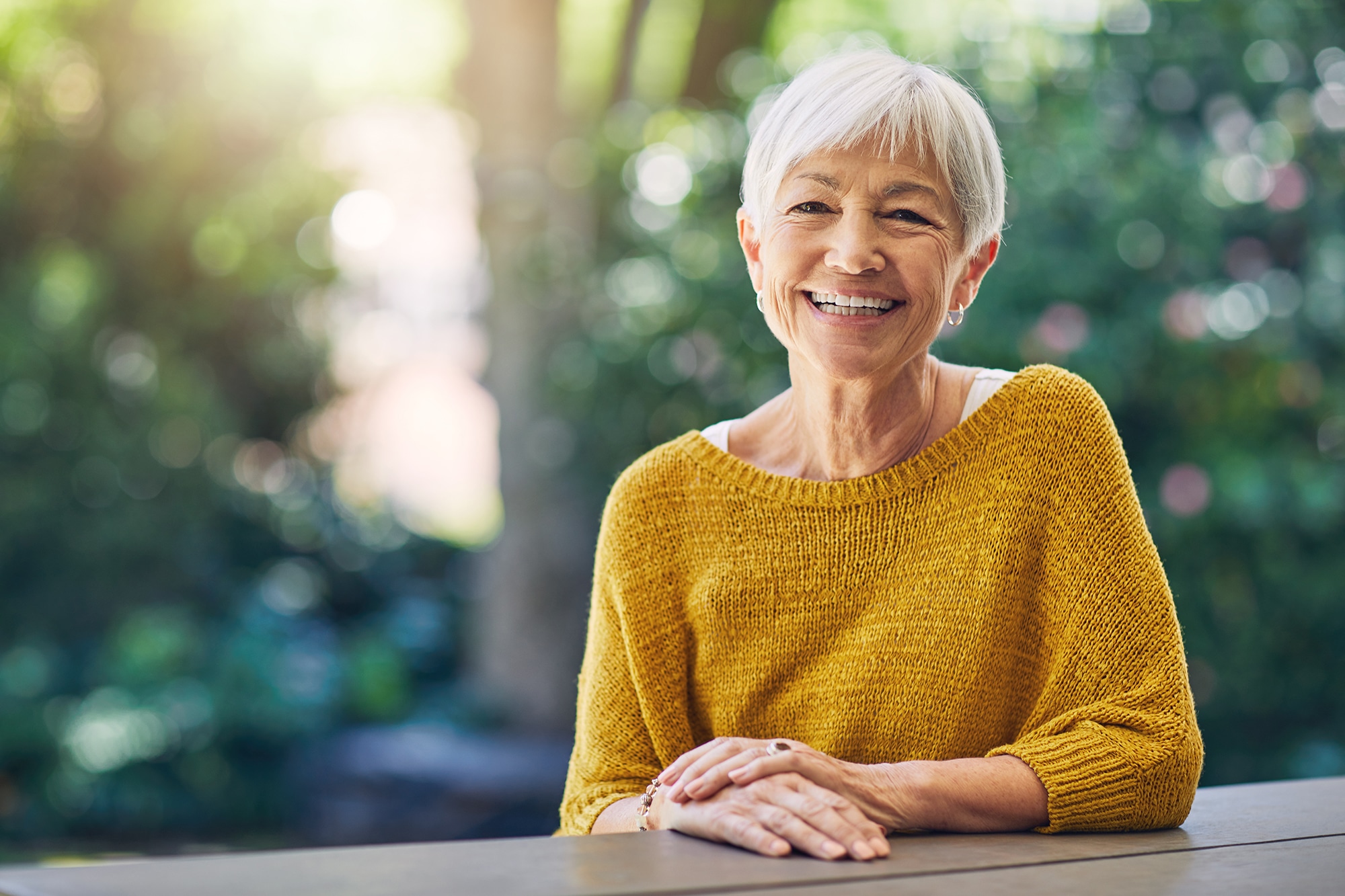 A senior patient smiling outdoors